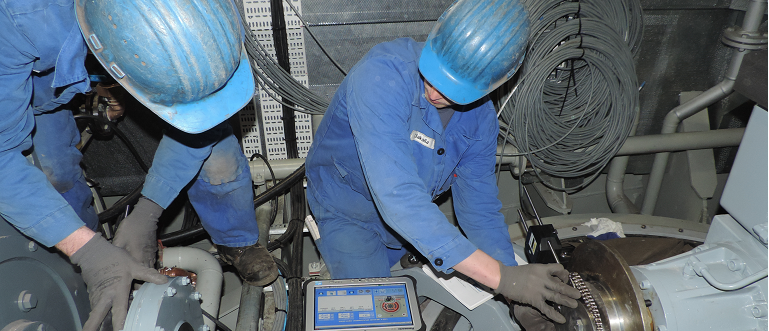 pair of technicians performing a shaft alignment while watching the live view on the tablet
